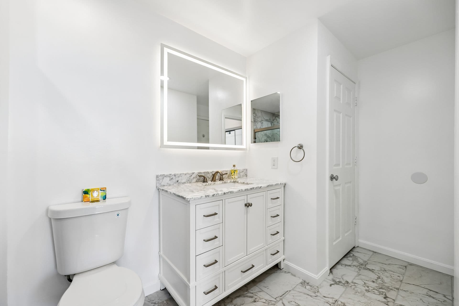 Full bathroom remodel with marble tile, glass shower enclosure, and modern vanity