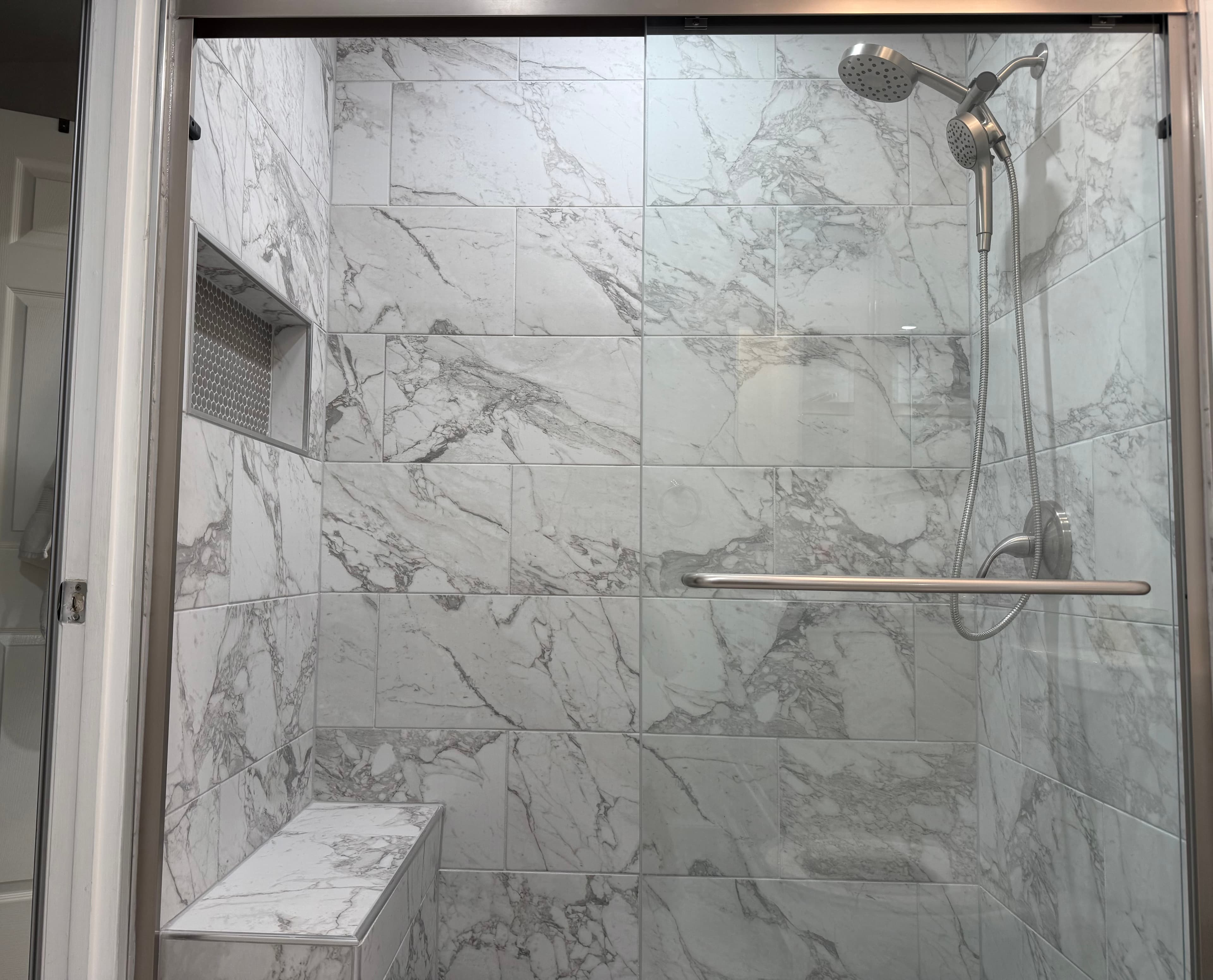Glass shower enclosure with built-in bench and niche